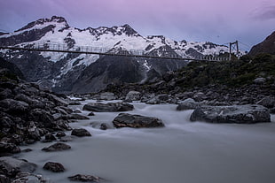 photo of black bridge and mountain covered with snow