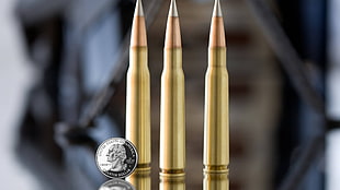 three rifle bullets, ammunition, coins, money, metal