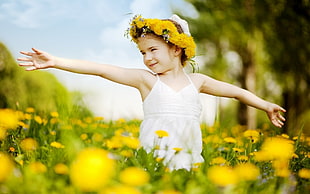 tilt lens photography of girl with floral headband on flower field