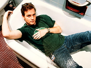 man in green shirt and blue jeans in bath tub