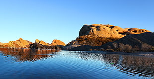 rock mountains reflecting over waters HD wallpaper