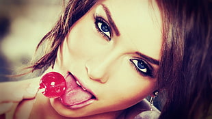 woman licking red lollipop