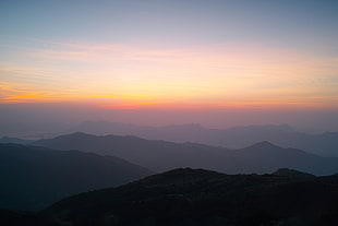 mountain hills under gray sky during sunset HD wallpaper
