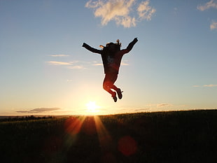 silhouette of person jumping with view of the horizon HD wallpaper
