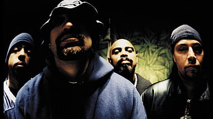 man wearing blue hoodie standing in between three men