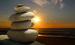 balance stone near calm water of beach