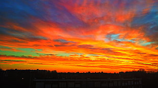 red, yellow, and blue abstract painting, sunset, sky, sunlight, clouds