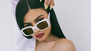 woman wearing red lipstick, black eyebrows, and white sunglasses