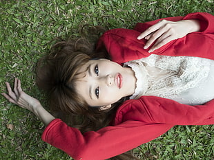 woman in red hoodie lying on green grass field HD wallpaper