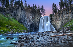 waterfalls surrounded by gray cliffs during daytime