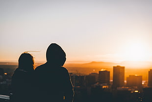 silhouette of two people looking at buildings