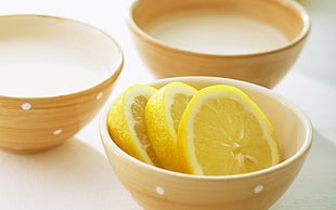 sliced lemons on brown bowl