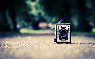selective focus photography of gray and black camera on concrete road
