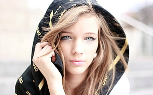 shallow focus photograph of woman wearing black and yellow hooded jacket
