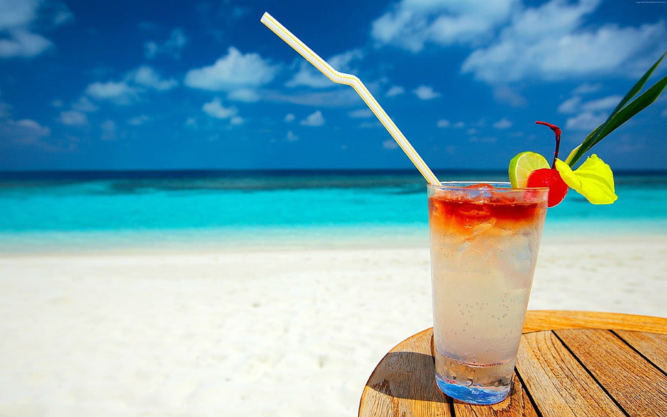 clear glass cup with straw near white beach HD wallpaper