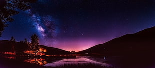 silhouette of mountain under purple and black starry sky photo