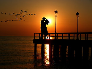 silhouette of man an woman kissing during sunset HD wallpaper