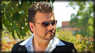 man wearing white collared top while wearing sunglasses