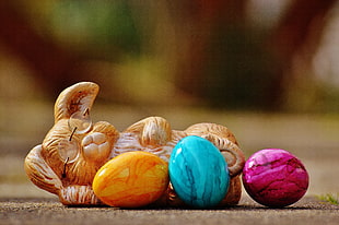sleeping rabbit figurine with orange, pink, and teal eggs