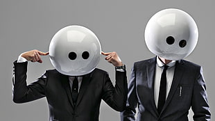two men wearing suit standing with gray background