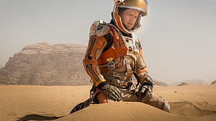 man in astronaut suit with desert background