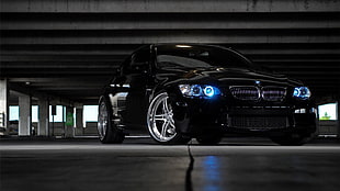 black BMW car inside indoor parking area HD wallpaper