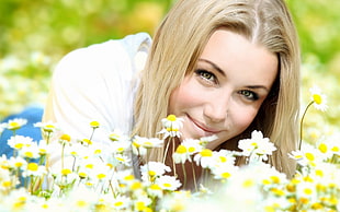 tilt lens photography of woman surrounded by daisy flowers