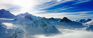 landscape photography of sea of clouds on snowy mountains under stratus clouds during daytime