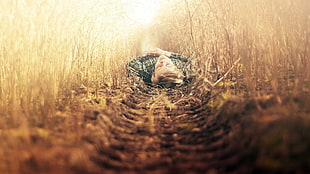 man in gray sports shirt laying on brown grass field