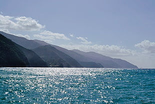 Mountain ranges across Ocean during daytime HD wallpaper