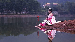 woman sitting near body of water
