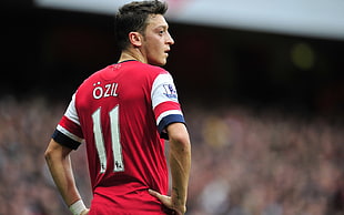 man wearing white and red Ozil 11 jersey shirt