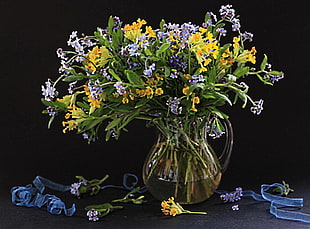 yellow and purple flowers in clear vase