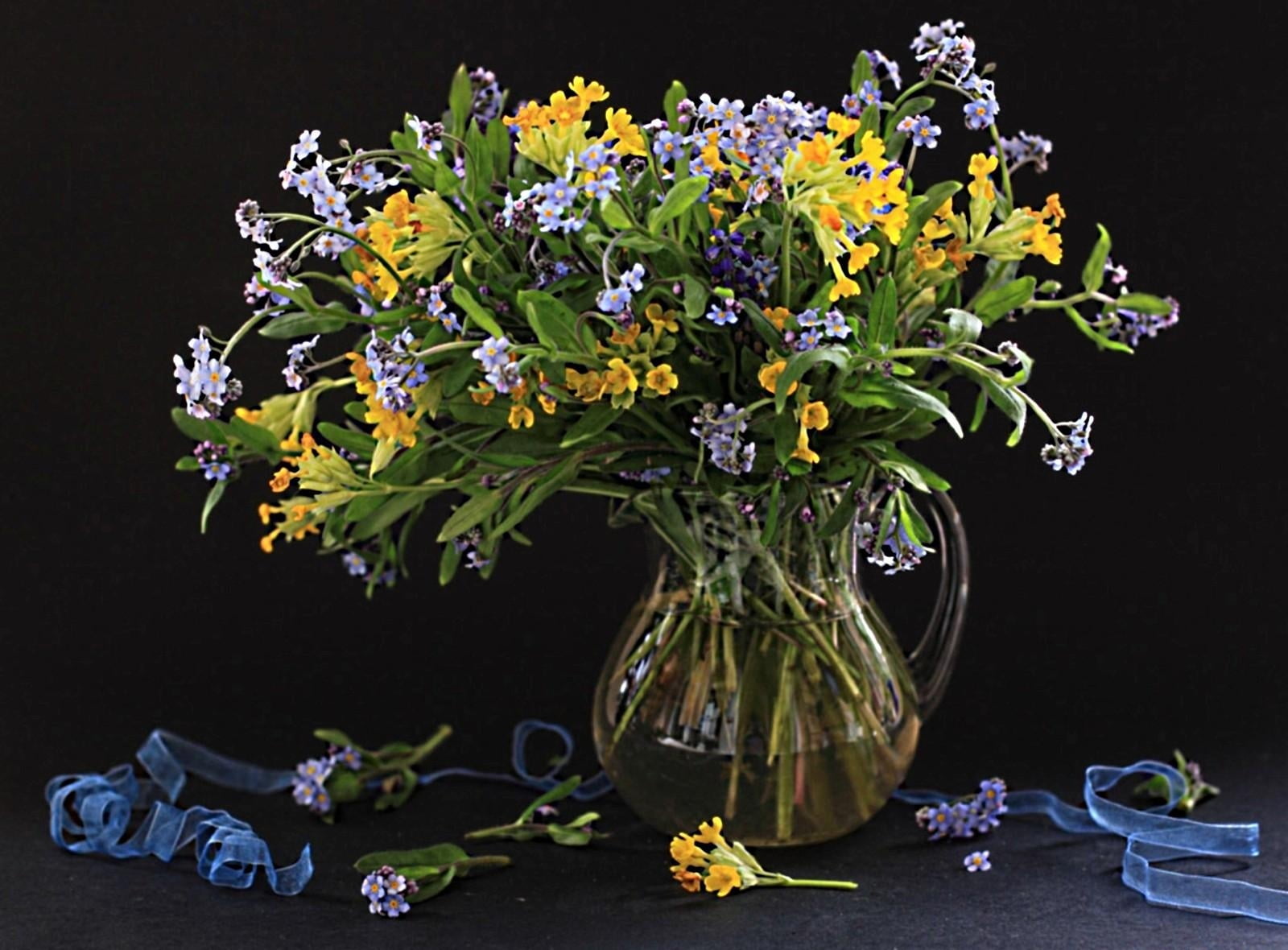 yellow and purple flowers in clear vase