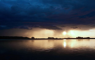 silhouette of island, lake, clouds, sunlight, reflection