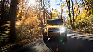 yellow Mercedes-Benz G-class SUV on asphalt road