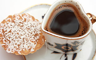 black coffee with baked biscuit serving on white and black ceramic plate