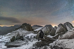 person in grey hoodie on top of a mountain during the night time, glyder fach, snowdonia