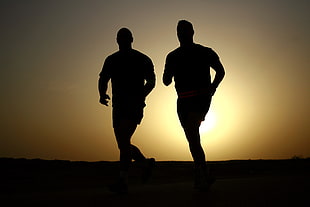 silhouette of two man jogging during golden hour HD wallpaper