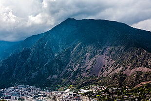 village surrounded with mountain under dark heavy clouds