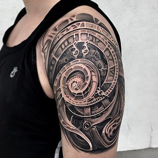man with mechanical clock tattoo on left shoulder