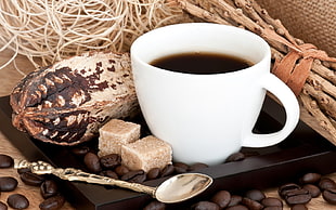 filled coffee mug near silver spoon
