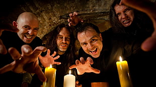 4-man music band poses in front of candles