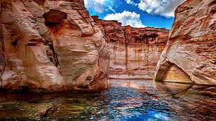 photo of bodies of water in between of rocks HD wallpaper