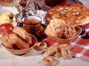 four baked breads beside filled cup