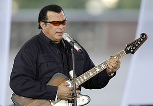 Steven Seagal playing guitar while singing