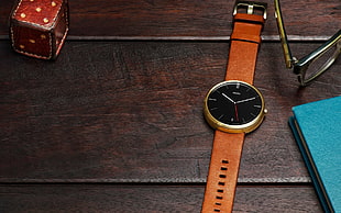 round gold-colored analog watch with brown leather band
