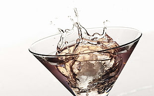 photo of martini glass filled with liquor and ice cube