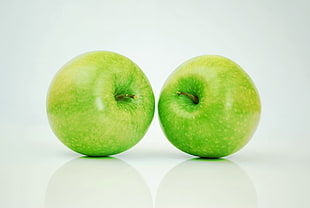 two round green apples with white background