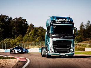 blue freight semi- truck on track with silver Koenigsegg Agera R